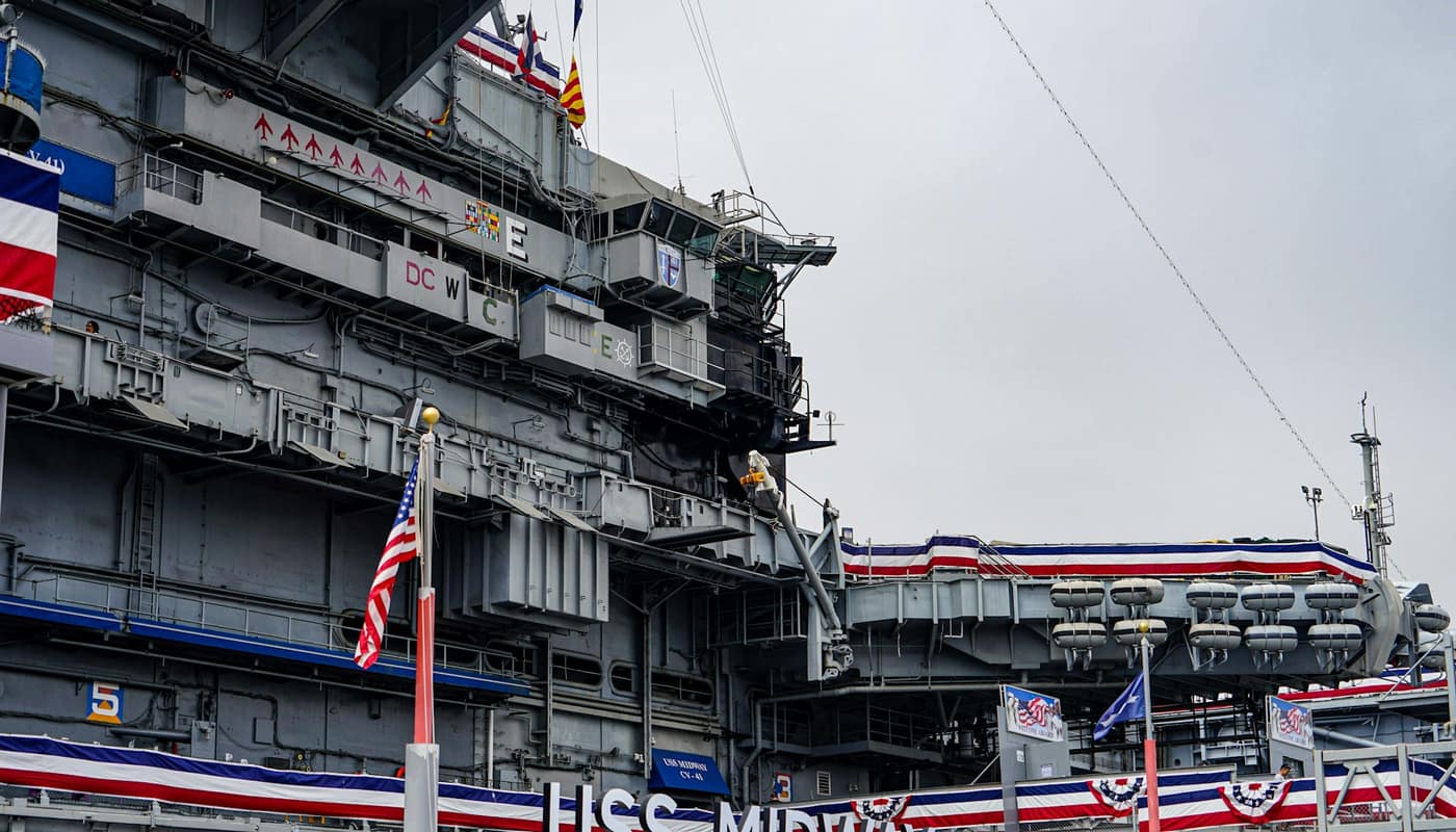 A large naval vessel docked along a waterfront
